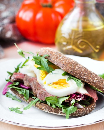 Sandwich with grilled beef steak, eggs, arugula, rye bread, tatsy lunchの写真素材