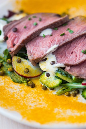 Salad with grilled beef steak, black lentils, rocket, radish, cucumber, orange spice turmericの写真素材