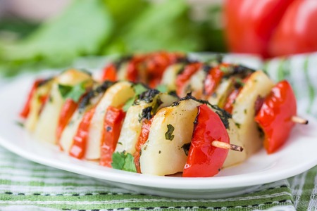 Potato vegetarian kebab, skewer with vegetables, tomato, herb on stick, tasty picnic dishの写真素材
