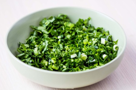 Green chopped herbs in bowl, parsley, ramson, spring onionの写真素材