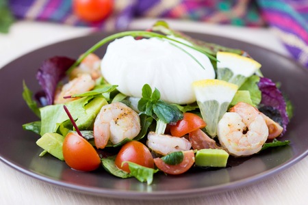 Fresh salad with shrimps, tomatoes, herbs, avocado, poached egg, delicious summer dishの写真素材