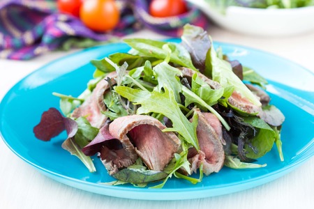 Green salad with grilled beef steak medium rare, mix lettuce, arugula, tasty fresh dishの写真素材