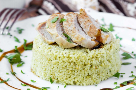 Couscous with pesto sauce, fried sliced pork, tasty dish, beautiful presentationの写真素材