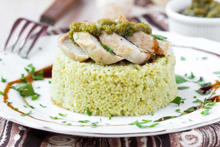 Couscous with pesto sauce, fried sliced pork, tasty dish, beautiful presentationの写真素材