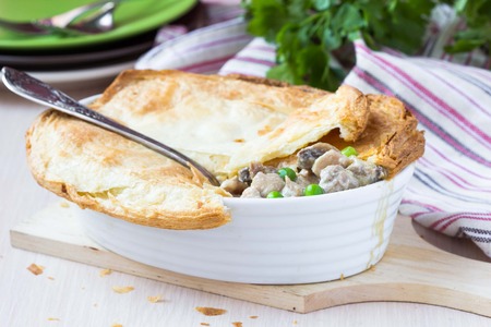 Meat pie with stew of chicken, mushrooms, peas, puff pastry crust, tasty homemade dishの写真素材
