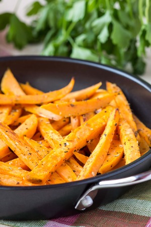 Sweet potatoes, batata, sliced, fried in pan with spices, herbの写真素材