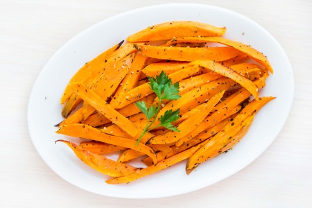 Sweet potatoes, batata, sliced, fried with spices, herb on plate, isolatedの写真素材