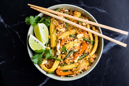 Asian fried rice with egg, vegetables, mini corn, peppers, green beans, delicious Chinese dinnerの写真素材