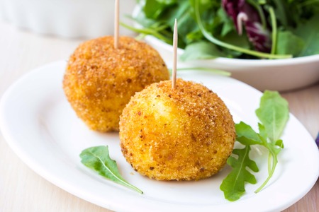 Italian appetizer arancini, rice balls stuffed with meat cooked in deep fatの写真素材