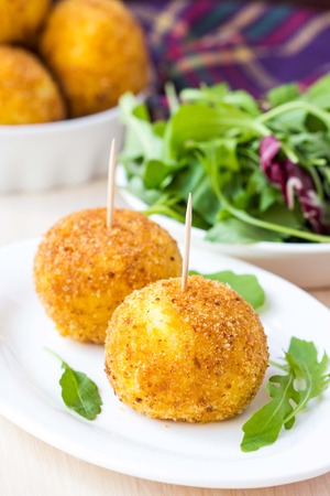 Italian appetizer arancini, rice balls stuffed with meat cooked in deep fatの写真素材