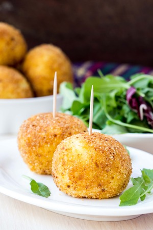 Italian appetizer arancini, rice balls stuffed with meat cooked in deep fatの写真素材