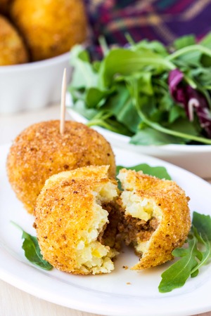 Italian appetizer arancini, rice balls stuffed with meat cooked in deep fatの写真素材