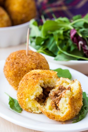 Italian appetizer arancini, rice balls stuffed with meat cooked in deep fatの写真素材