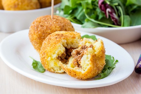 Italian appetizer arancini, rice balls stuffed with meat cooked in deep fatの写真素材