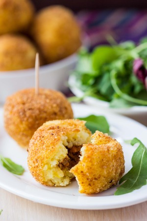 Italian appetizer arancini, rice balls stuffed with meat cooked in deep fatの写真素材
