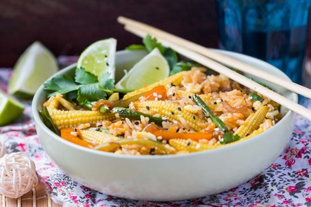 Asian fried rice with egg, vegetables, mini corn, peppers, green beans, delicious Chinese dinnerの写真素材