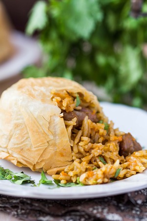 Oriental shah pilaf, pilaw, plov, rice with meat in pastry filo, delicious fragrant spicy dishの写真素材