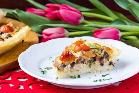 French pie quiche with tomato, ham, egg, cheese, mushrooms, tasty dishの写真素材