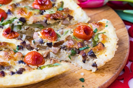 French pie quiche with tomato, ham, egg, cheese, mushrooms, tasty dishの写真素材