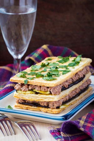 French appetizer millefeuille with eggplant, mousse, paste, cream of beans and meatの写真素材