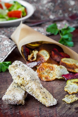 Diet fish and vegetable crisps in paper, low-calorie tasty dishの写真素材