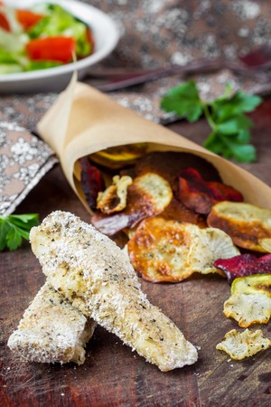 Diet fish and vegetable crisps in paper, low-calorie tasty dishの写真素材