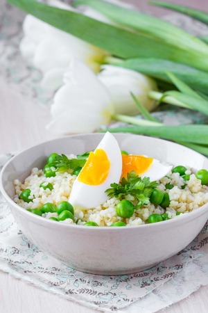Bulgur, rice with green peas, boiled egg yolk, spring, summerの写真素材