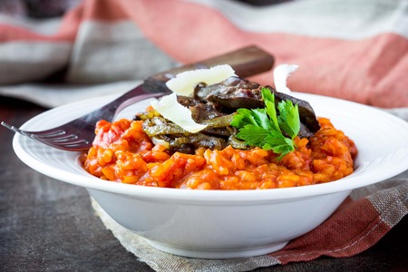 Tomato risotto, red rice with fried chicken liver, onions, homemade Italian dishの写真素材