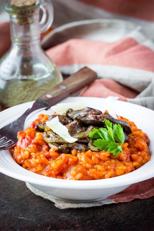 Tomato risotto, red rice with fried chicken liver, onions, homemade Italian dishの写真素材
