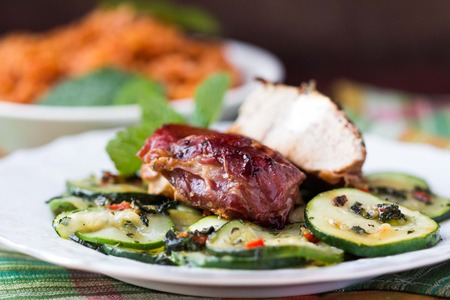 Pork steak, meat stuffed with feta cheese with bacon pancetta and zucchini saladの写真素材