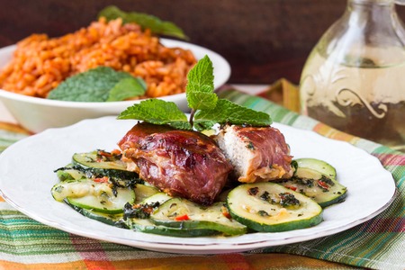 Pork steak, meat stuffed with feta cheese with bacon pancetta and zucchini saladの写真素材
