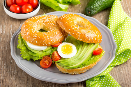 Bagel sandwich with avocado, boiled egg, green salad lettuceの写真素材