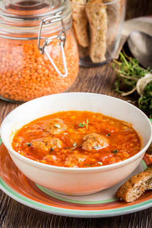 Hot aromatic rich tomato soup with meatballs, vegetables, red lentils, thyme, tasty homemade first course, food, dinnerの写真素材