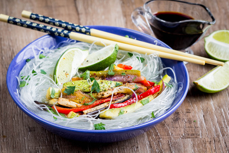 Cellophane rice noodles with vegetables, soy sauce, broth, a vegetarian dish with zucchini, eggplant, pepper, lime, delicious Asian foodの写真素材
