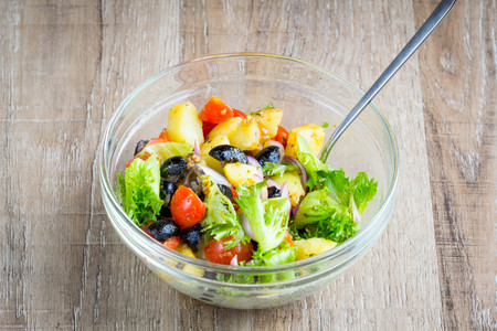 Potato salad with olives, tomatoes, lettuce, red onion, Italian dish, delicious foodの写真素材