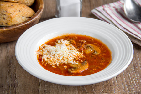 Italian soup with tomatoes, mushrooms, minced meat, cheese, vegetables, delicious dishの写真素材