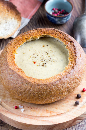 Cream soup of potatoes, vegetables, cheese, mushrooms, serve in bread, rustic style, delicious foodの写真素材