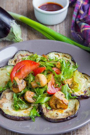 Salad with eggplant, mushrooms, tomato, lettuce and sauce, a delicious homemade dish, rustic styleの写真素材