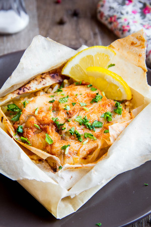 White fish fillet baked in parchment with rice and vegetables, delicious healthy dish, diet foodの写真素材