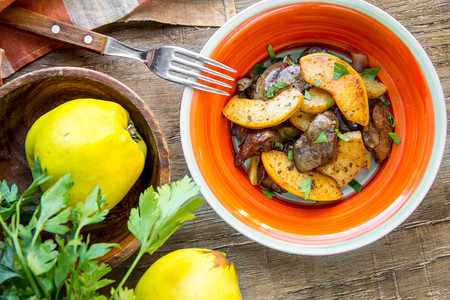 Meat, chicken liver with quince, apples, spices, delicious homemade autumn dishの写真素材