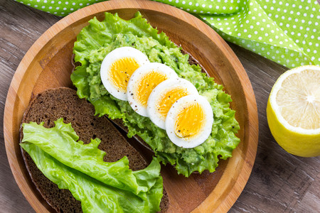Sandwich with bread, mashed avocado, sliced eggs, green salad, delicious breakfast, healthy foodの写真素材