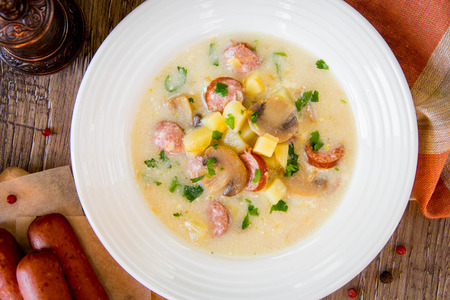 Cheese cream soup with mushrooms, potatoes, smoked sausage, German tasty dishの写真素材