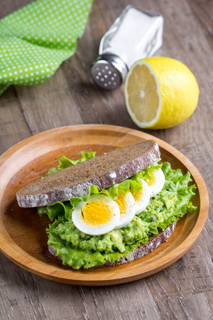 Sandwich with bread, mashed avocado, sliced eggs, green salad, delicious breakfast, healthy foodの写真素材