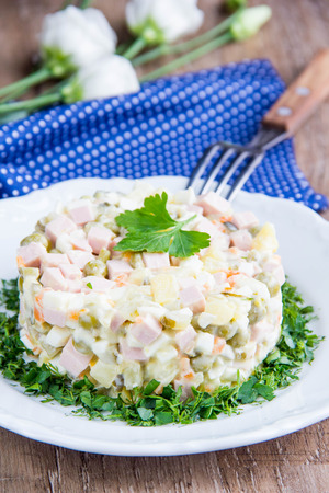 Classic Russian salad with sausage, peas, potatoes, carrots and mayonnaise, delicious traditional dishの写真素材