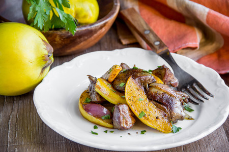 Meat, chicken liver with quince, apples, spices, delicious homemade autumn dishの写真素材