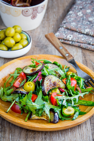 Warm salad with eggplant, arugula, cherry tomatoes, olives, delicious healthy dinner, summer dish, diet foodの写真素材