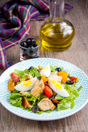 Green salad with chicken, lettuce, egg, olives, tomatoes, healthy lunch, tatsy dishの写真素材