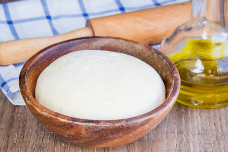 Dough in wooden bowl, yeast for pizza, pasta, cake, pie, tasty foodの写真素材