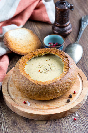Cream soup of potatoes, vegetables, cheese, mushrooms, serve in bread, rustic style, delicious foodの写真素材