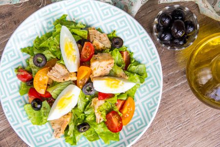 Green salad with chicken, lettuce, egg, olives, tomatoesの写真素材